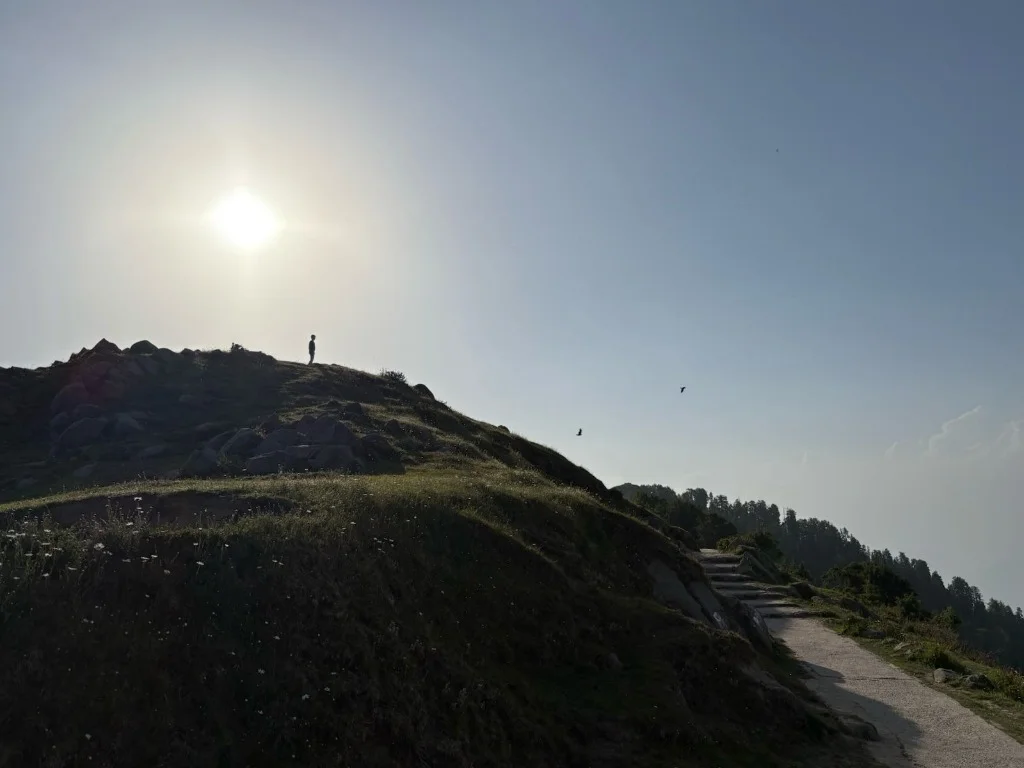 Silhouette on mountain peak under bright sun
