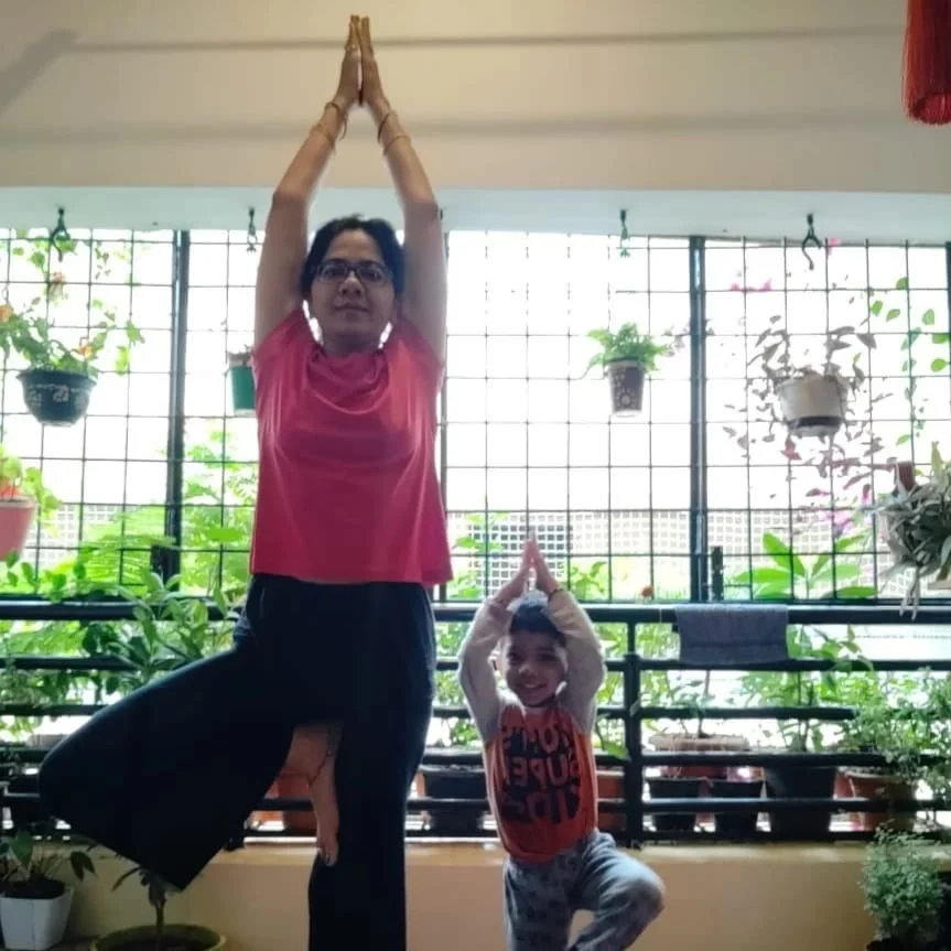 Aayaan doing tree pose yoga with his mother